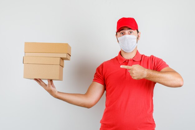 Entregador apontando para caixas de papelão em camiseta vermelha