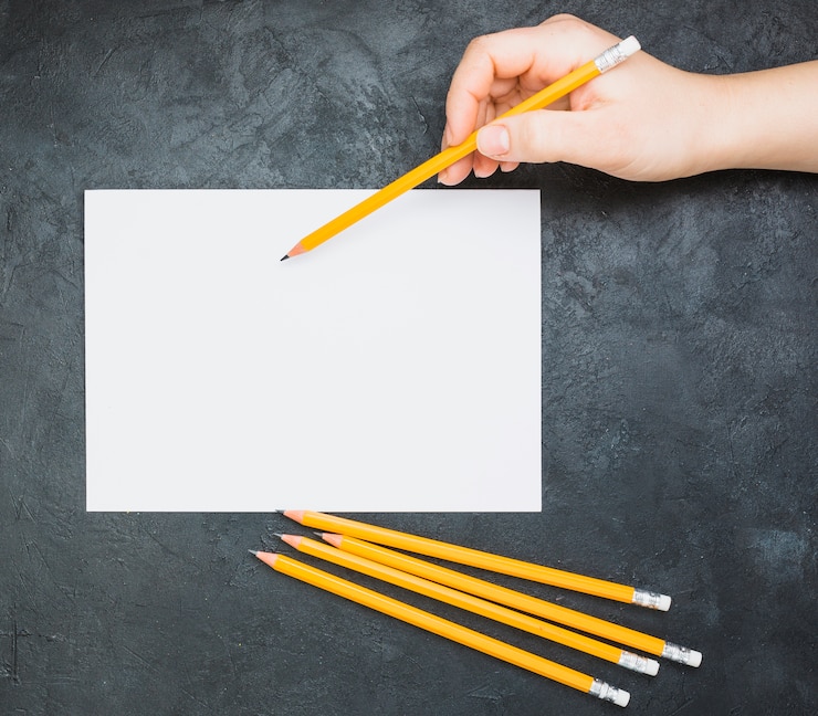 Foto grátis entregue o esboço no papel branco em branco com um lápis no fundo preto