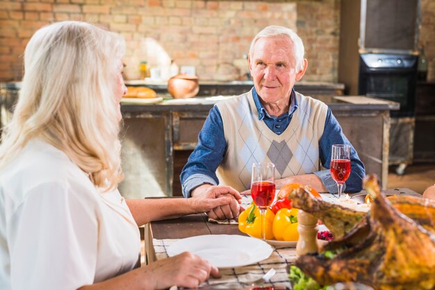 Envelhecido casal sentado à mesa com comida