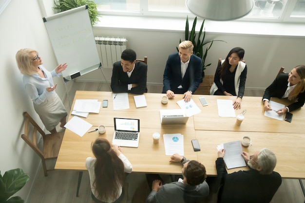 Envelhecido, executiva sênior, dar, apresentação, em, multiracial, grupo, escritório, reunião