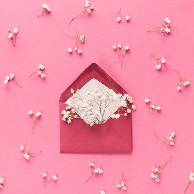 Envelope com ramos de flores brancas na mesa