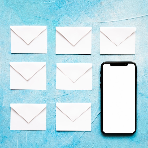 Envelope de papel branco de ícones de mensagem com celular em fundo azul