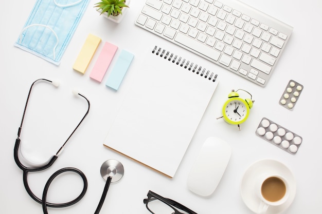 Equipamento médico e material de escritório com xícara de café sobre a mesa do médico