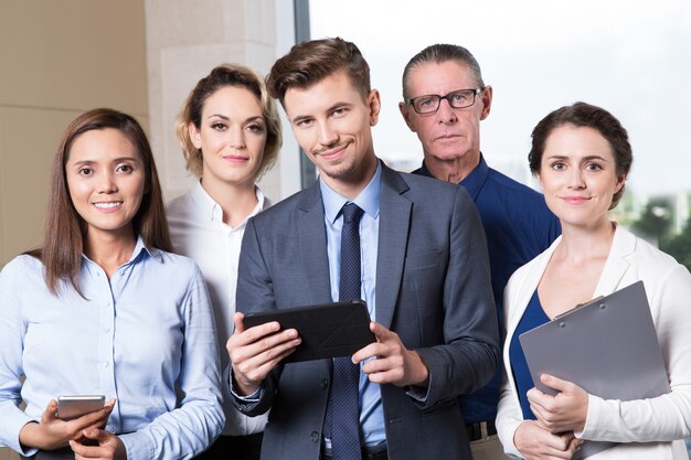 Equipe bem sucedida do negócio que olha a câmera