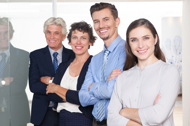 Equipe bem sucedida que está no flipchart e sorrindo