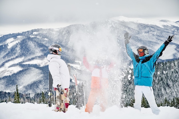 Equipe de esquiadores se divertindo em montanhas nevadas