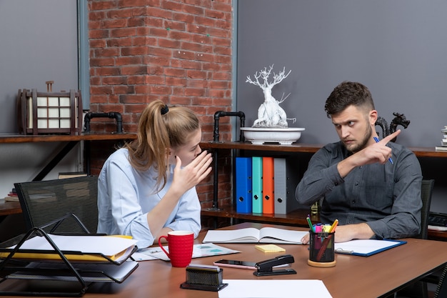 Equipe de gerenciamento ocupada e cansada discutindo uma questão importante no escritório