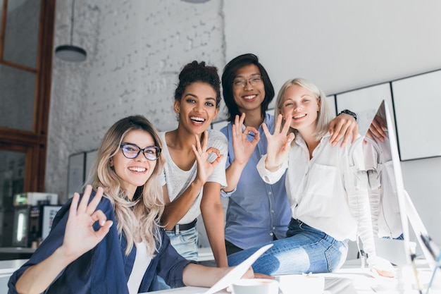 Equipe de jovens desenvolvedores da web talentosos com projetos difíceis e posando com um sorriso