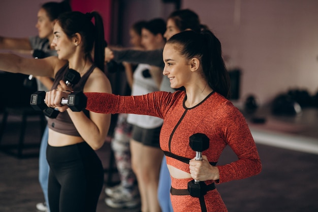 Equipe de meninas exercitando aeróbica juntos no ginásio