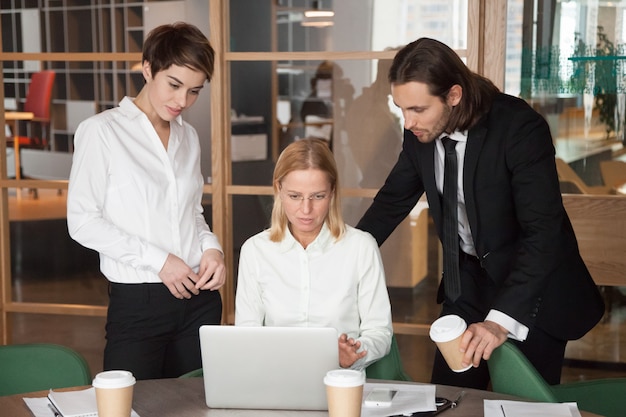 Equipe de negócios focada séria discutindo tarefa on-line juntos no escritório