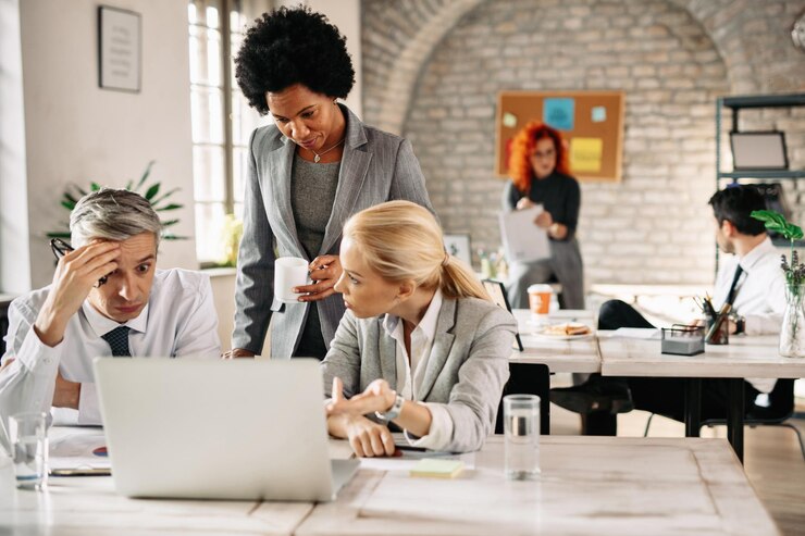Foto grátis equipe de negócios tendo problemas e conversando enquanto usa laptop no escritório o foco está na mulher de negócios afro-americana