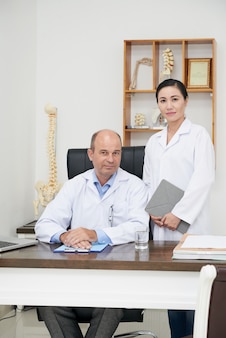 Equipe de osteopatas posando para uma foto no escritório do hospital