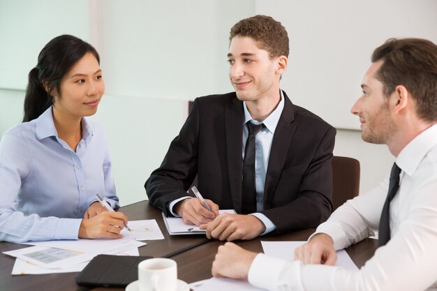 Equipe do negócio que discute idéias na Assembléia