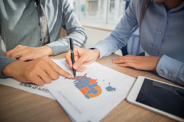 Equipe do negócio que estuda estatísticas de marketing EUA