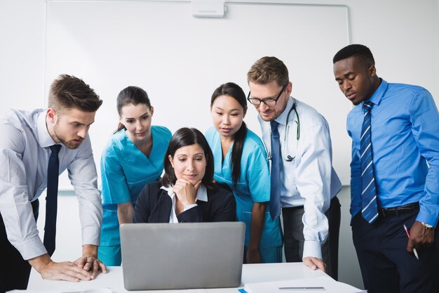 Equipe médica discutindo sobre laptop em reunião