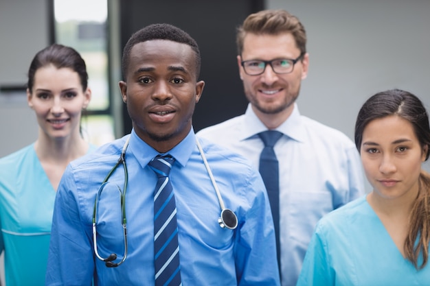 Equipe médica sorridente, reunida no corredor do hospital