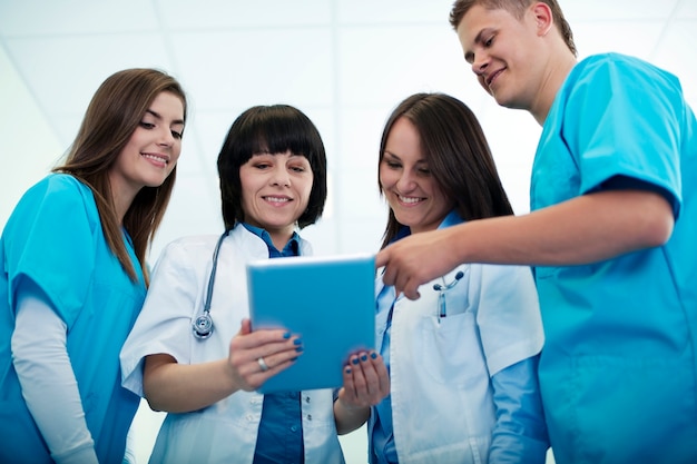 Equipe médica verificando resultados em tablet digital