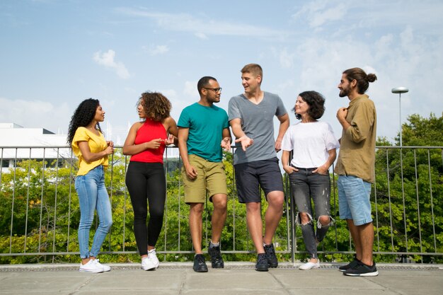 Equipe multiétnica de amigos conversando na ponte