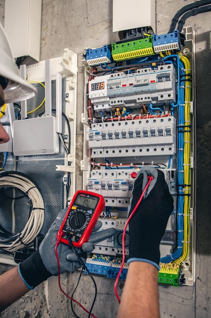 Equipe um técnico elétrico trabalhando em um quadro de distribuição com fusíveis