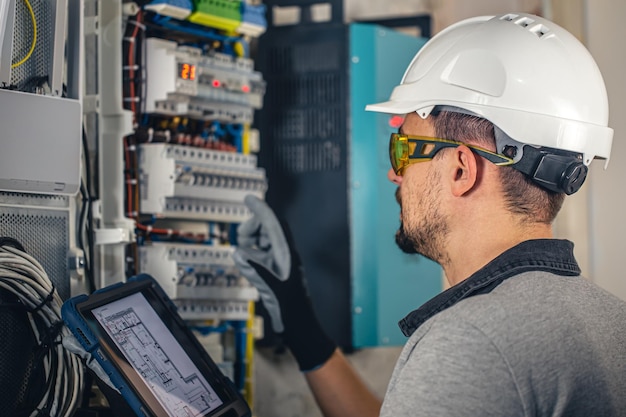 Foto grátis equipe um técnico elétrico trabalhando em um quadro de distribuição com fusíveis