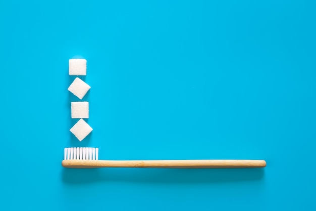 Foto grátis escova de dentes com cubos de açúcar em um plano de fundo azul