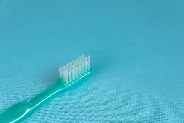 Escova de dentes turquesa na superfície azul