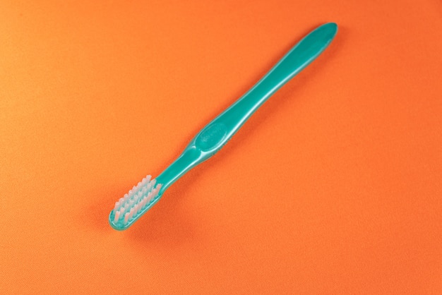 Escova de dentes verde na mesa laranja