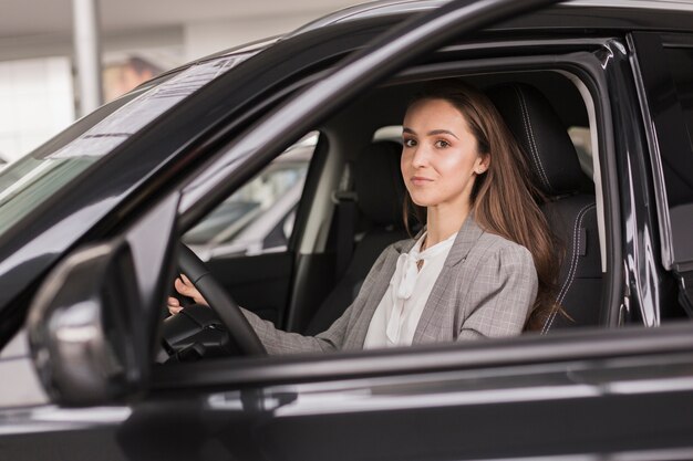 Escritório vestido mulher sentada em um carro moderno