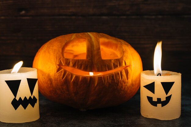 Esculpido o Halloween Jack-O-Lantern e velas na mesa