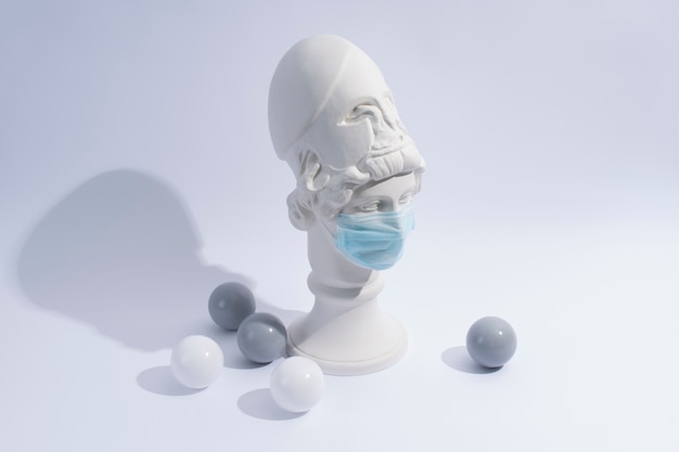Escultura de mármore de figura histórica com máscara médica e bolas