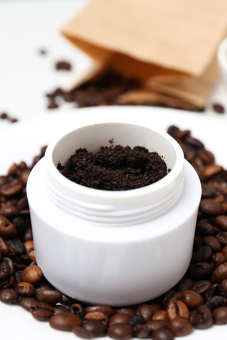 Foto grátis esfregão corporal de café num recipiente com grãos de café inteiros sobre um fundo branco