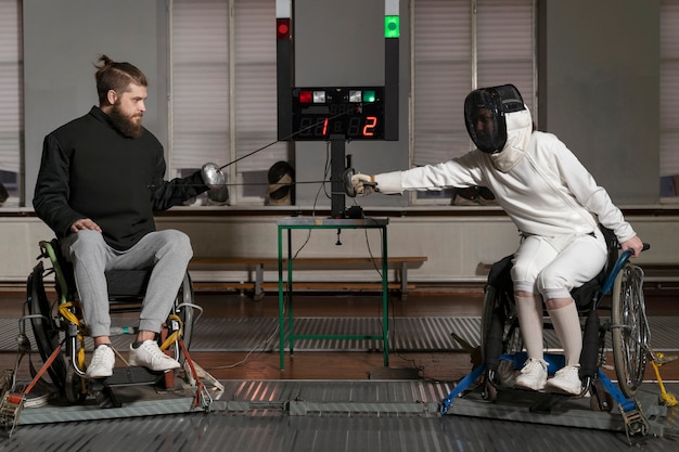 Foto grátis esgrimistas deficientes em equipamentos especiais lutando em suas cadeiras de rodas