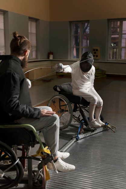Esgrimistas deficientes em equipamentos especiais lutando em suas cadeiras de rodas