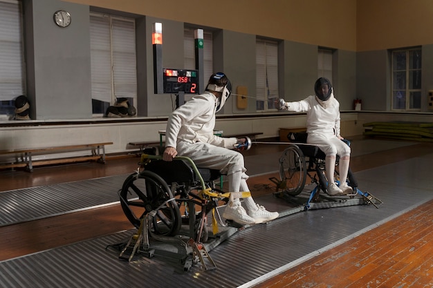Esgrimistas deficientes em equipamentos especiais lutando em suas cadeiras de rodas