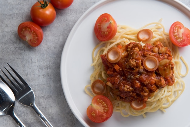 Espaguete com molho de tomate e salsicha em prato branco