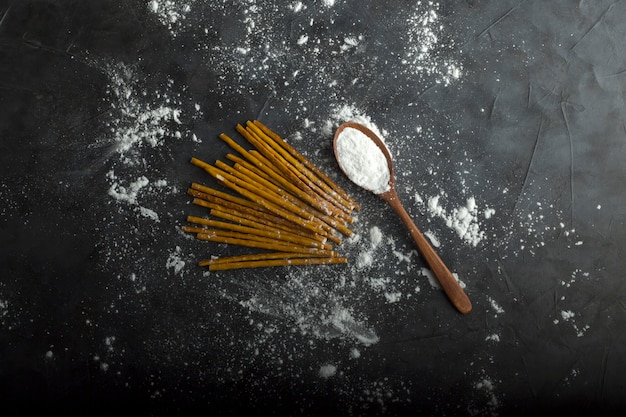 Espaguete cru com farinha na colher de pau