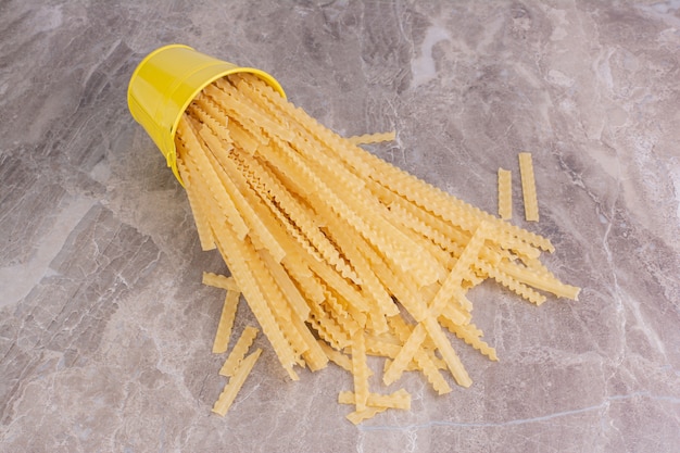 Foto grátis espaguete de um balde metálico amarelo.