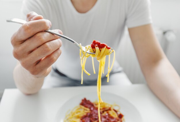 Espaguete saboroso antropófago novo com molho de tomate. Fechar-se.