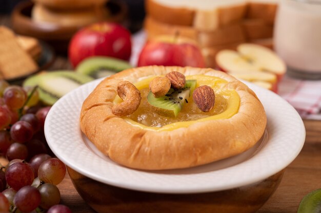 Espalhe o pão com geléia e coloque com kiwi e uvas