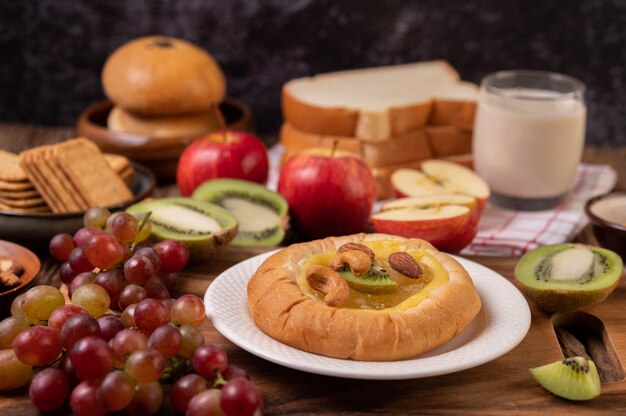 Espalhe o pão com geléia e coloque com kiwi e uvas