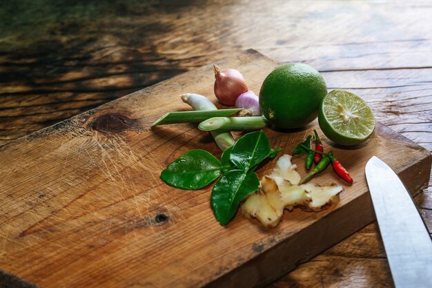 Especiarias Tom Yum que são colocadas em uma tábua de madeira marrom e têm uma madeira marrom escura.