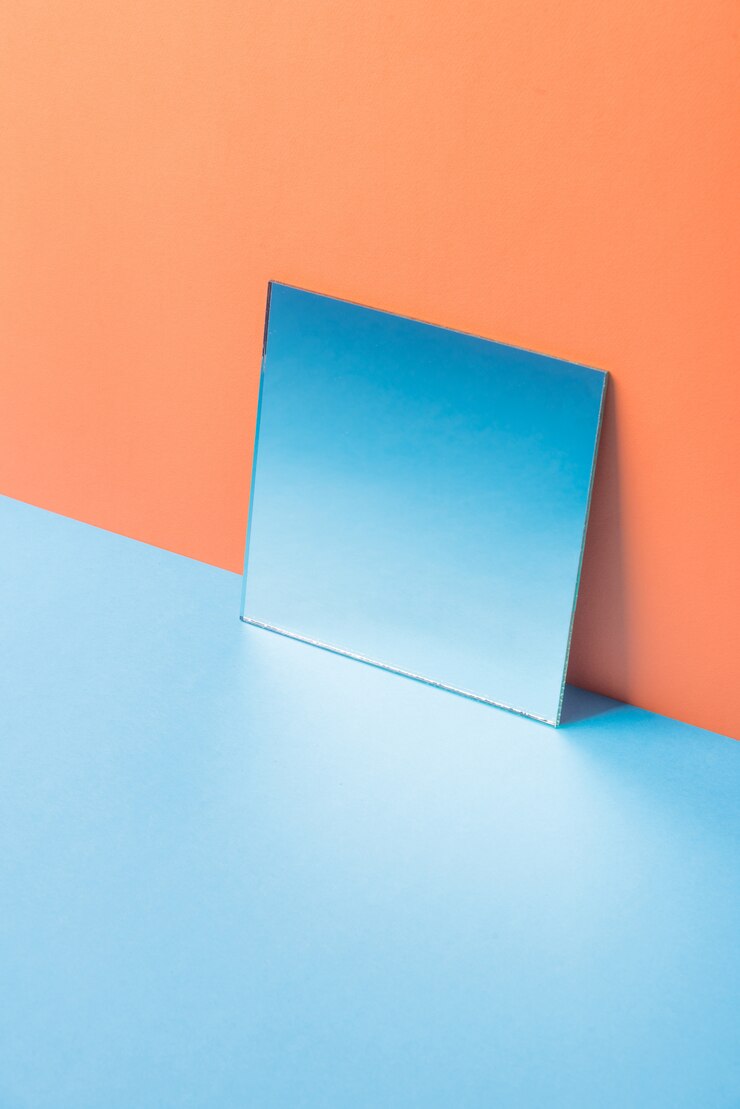 Foto grátis espelho na mesa azul isolada na laranja