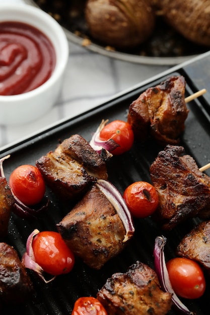 Foto grátis espetos de carne e tomate grelhados