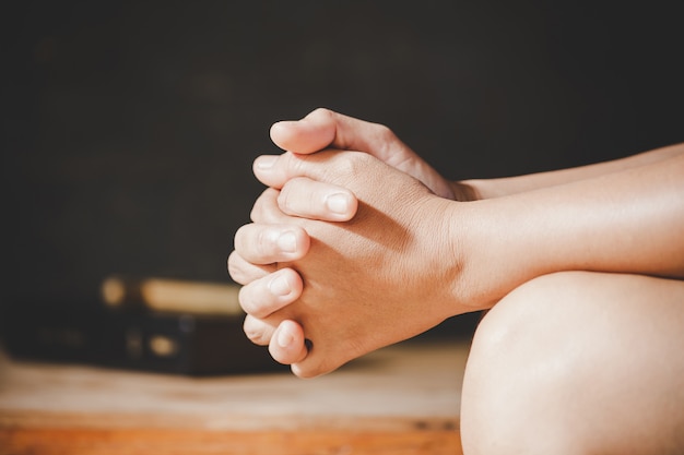 Foto grátis espiritualidade e religião, as mãos postas em oração sobre uma bíblia sagrada na igreja conceito de fé.