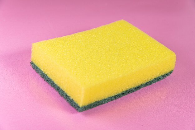 Esponja de cozinha na superfície rosa