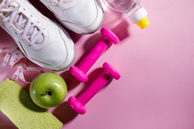 Esporte plano plano, conceito, equipamento de vida saudável, em fundo rosa brilhante. Closeup com espaço de cópia.