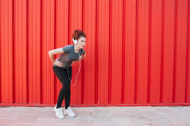 Esportista cansada em fones de ouvido