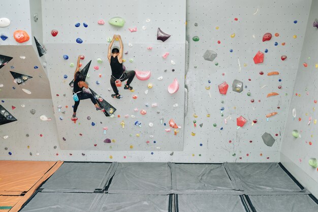 Esportivas pessoas malhando na parede de escalada