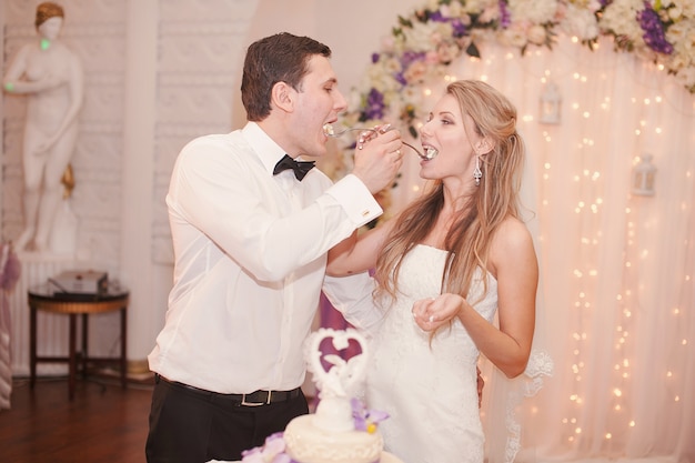 Esposa e marido dando-se comer