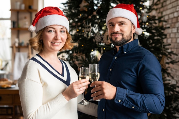 Esposa e marido torcendo com taças de champanhe no dia de natal